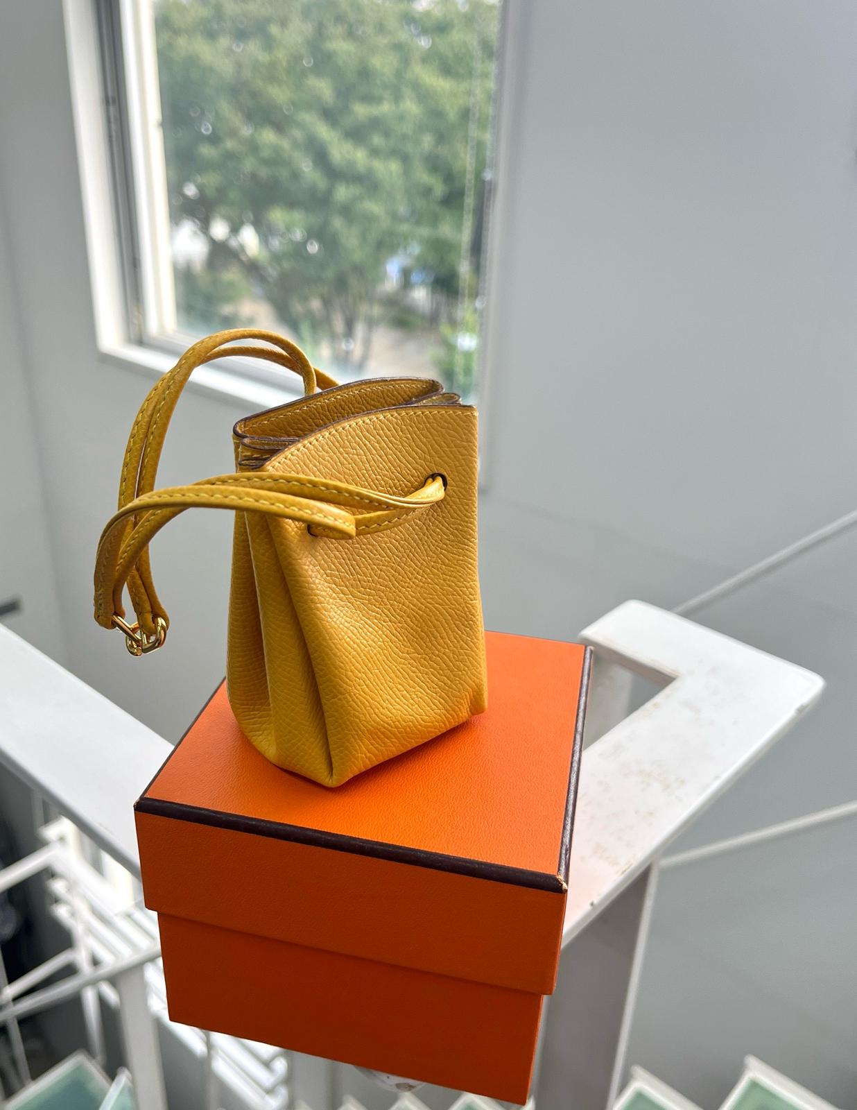 愛馬仕｜E皮抽繩mini小福袋pouch 黃色
框D刻 有盒 
可以當包掛裝飾 也可單獨當手拎小包
容量可以放口紅卡片鑰匙之類的
豬鼻子金扣開合設計 ～
$3328